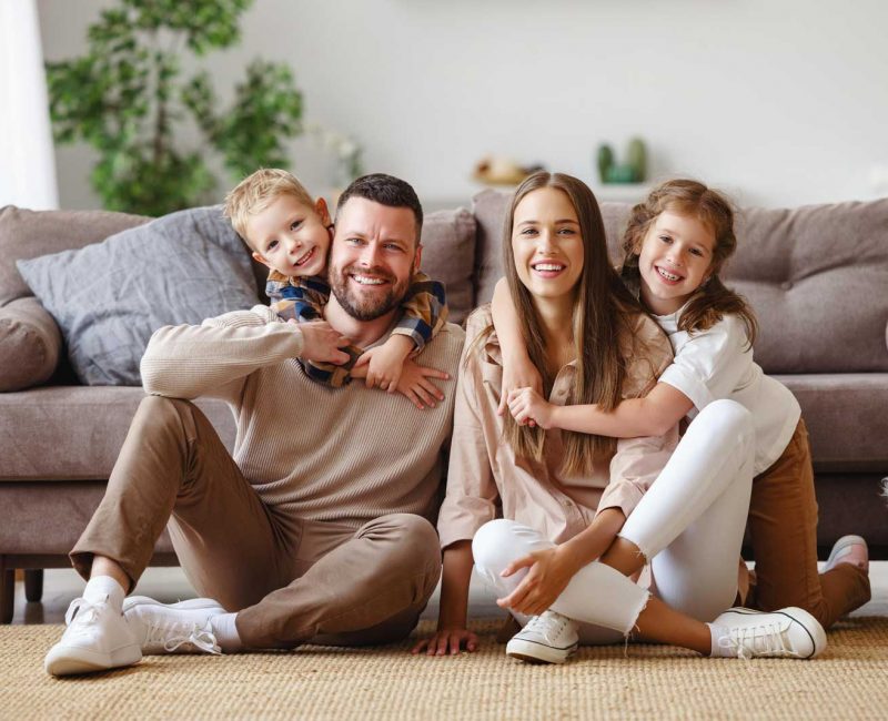 happy-family-mother-father-children-home-couch